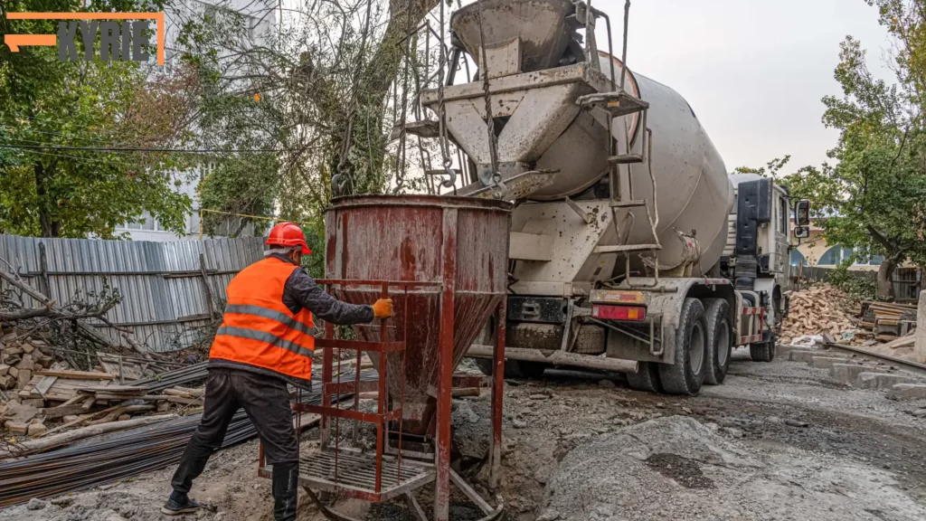 Construction worker with concrete truck showing How Much Does a Yard of Concrete Weigh.