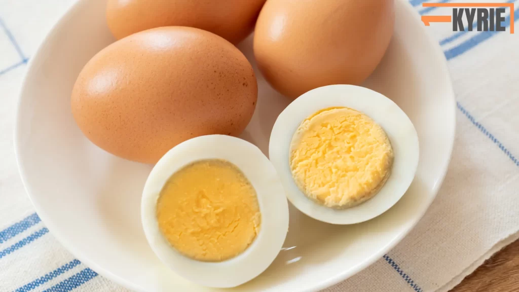 The image shows whole and halved boiled eggs. The answer to "Can you freeze boiled eggs?" is yes, but only the yolks freeze well. The egg whites can become rubbery and unappetizing when frozen.