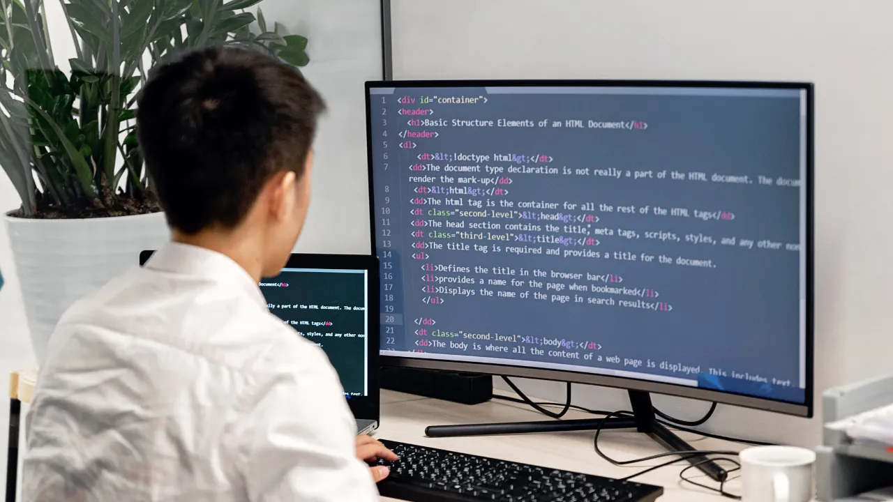 A team member reviewing code in a software engineering directorate, focused on HTML structure.